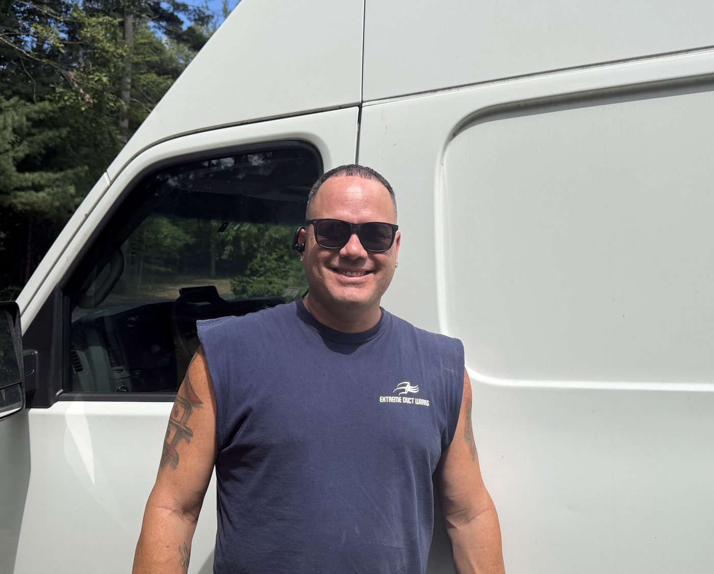 Nestor Morales, owner of Extreme Duct Works, standing by the work van